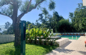 Swimmingpool og terrasse omgivet af grønne planter og træer på Glamping de Cerveira, Nordportugal.