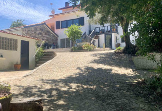 Holiday cottage at Glamping de Cerveira in North Portugal, featuring a cobbled path and lush green trees.