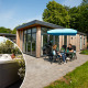 Udendørs terrasse ved en moderne lodge med spabad, hvor folk nyder både afslapning og hyggesnak.