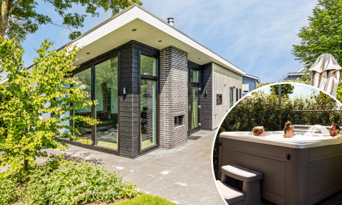 Moderne Natuurlodge Wellness met grote glaspartijen en gasten in een privé buitenjacuzzi in het zonnetje.