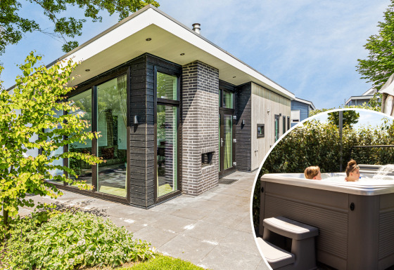 Moderne Natuurlodge Wellness met grote glaspartijen en gasten in een privé buitenjacuzzi in het zonnetje.