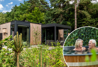 Moderne lodge in de natuur bij Bospark Ede, Nederland, met een ouder koppel in een buitenjacuzzi.