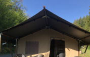 Tienda safari con terraza y muebles de exterior en Camping Bockenauer Schweiz, Alemania, día soleado