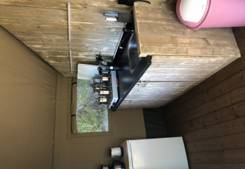 Zona de cocina en una tienda safari en Camping Bockenauer Schweiz con encimera, fregadero y nevera.