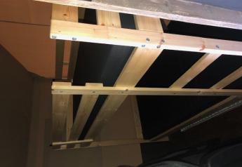 Vista interior de una cama de madera en una tienda safari con instalaciones sanitarias en Camping Bockenauer Schweiz.