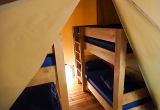 Interno della tenda Safari presso Camping Pittoresque in Francia con letti a castello e pavimento in legno.