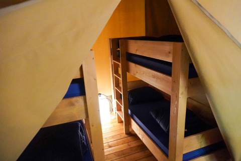Interior view of Safari tent at Camping Pittoresque in France featuring bunk beds and a wooden floor.