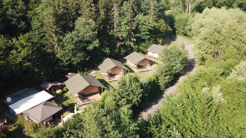 Vue aérienne des tentes safari au Camping Bockenauer Schweiz, Allemagne, entourées de forêts verdoyantes.