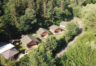 Vista aerea delle tende safari al Camping Bockenauer Schweiz, Germania, circondate da una foresta verde.