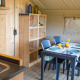 Innenansicht eines Safarizelts mit Esstisch, Stühlen, Holzmöbeln und Küche auf Camping de Boomgaard.