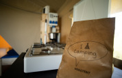 Indvendig i et safaritelt med gaskomfur og papirpose med teksten 'I love camping' fra Vodatent.