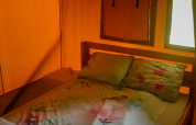 Vista interior de una tienda safari con cama doble y ventanas, Safari tent en Camping du Rivage en Luxemburgo.