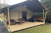 Tienda safari con terraza de madera cubierta y muebles exteriores en Camping du Rivage, Luxemburgo