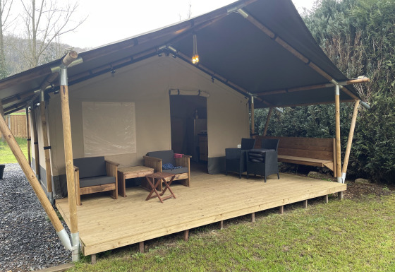 Safari-Zelt mit überdachter Holzterrasse und Sitzgelegenheiten bei Camping du Rivage in Luxemburg