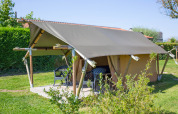 Tienda safari Duo Lodge en Camping de Boomgaard, Bélgica, estructura de madera y sillas exteriores.