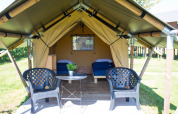 Tienda safari Duo Lodge en Camping de Boomgaard, Bélgica, con dos camas, sillas y mesa exterior.