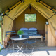 Tienda safari Duo Lodge en Camping de Boomgaard, Bélgica, con cama y mesa con sillas en la terraza.