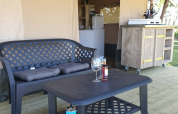 Gemütlicher Außenbereich mit Sofa und Tisch vor einer Safarizeltküche auf Camping Eefting, Niederlande.
