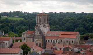 Vista de La Flocellière en Pays de la Loire, Francia, con su iglesia distintiva y techos rojos.