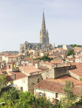 Vista de La Flocellière con tejados rojos y una iglesia destacada en el centro, Pays de la Loire, Francia.
