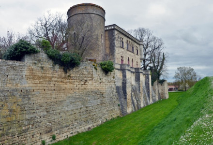 Antiguo castillo con muros de piedra y torre redonda cerca de La Flocellière, Pays de la Loire, Francia, en un día nublado.