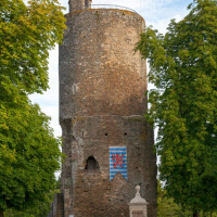 Torre de piedra medieval rodeada de árboles cerca de La Flocellière, Pays de la Loire, Francia, a la luz del día.