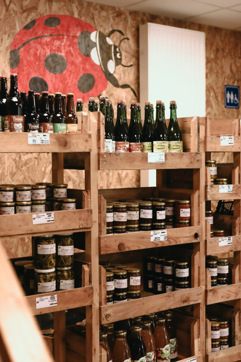 Estantes con productos locales y botellas en Feather Down Les Jardins des Coccinelles, Bretaña, Francia.