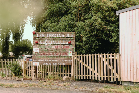 Entrance sign for Les Jardins des Coccinelles, a holiday park and farm in Brittany, France