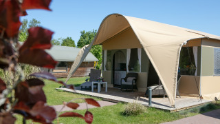 Tienda safari de lujo Lodge en Holiday Park 't Rheezerwold, Países Bajos, con terraza y muebles exteriores.