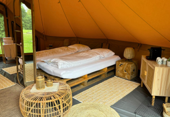 Safari tent Bivak Deluxe - Gent at Urban-Gardens, Belgium, featuring a cozy bed and natural wood decor.
