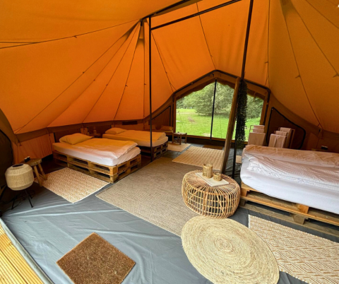 Interieur van de Bivak Deluxe - Gent safaritent bij Urban-Gardens in België met bedden en gezellige meubels.