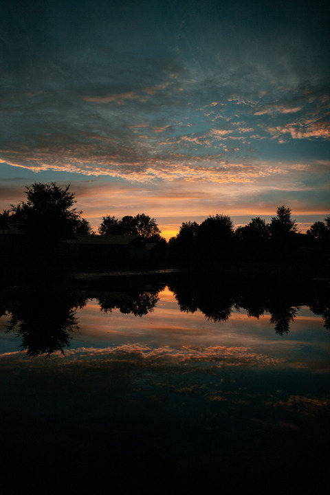 Suggestivo tramonto su un lago riflettente presso la Tiny house al Holiday park Eigen Wijze, Paesi Bassi.