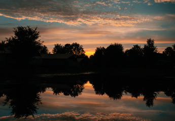 Smuk solnedgang over en sø med spejlblankt vand ved Tiny house i Holiday park Eigen Wijze, Nederlandene.