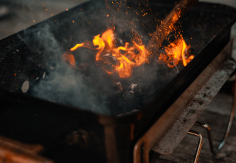 Fuego ardiendo en una parrilla portátil sobre una terraza de madera en la Tiny House de Holiday park Eigen Wijze, Países Bajos.