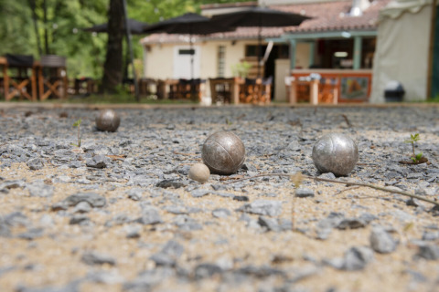 Bolas de petanca en una cancha de grava en Camping Pittoresque, un parque de vacaciones en Occitania, Francia.