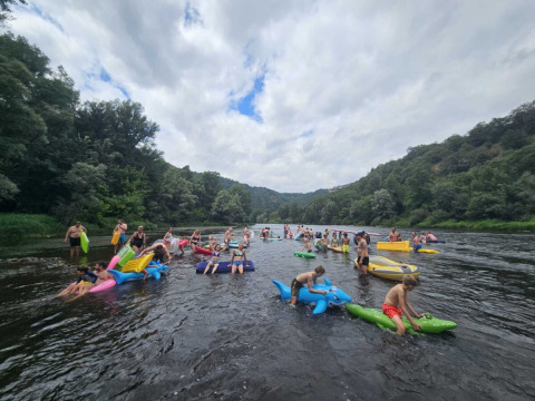 Persone galleggiano su gonfiabili colorati sul fiume al Camping Pittoresque in Occitanie, Francia.