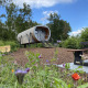 Anthropod tiny house i naturen ved Holiday Park 't Rheezerwold i Holland med vilde blomster foran.