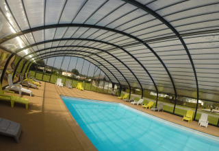 Overdækket swimmingpool med liggestole på Camping Seasonova Les Marguerites i Hauts-de-France, Frankrig.
