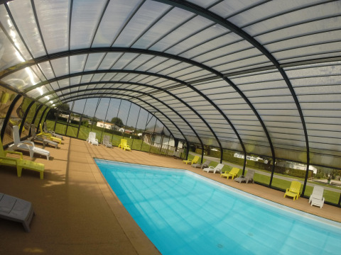 Covered swimming pool area with sun loungers at Camping Seasonova Les Marguerites, Hauts-de-France, France.