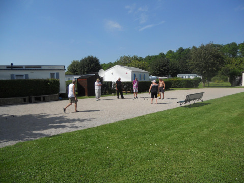 Un gruppo di persone gioca a un gioco all'aperto su ghiaia al Camping Seasonova Les Marguerites in Francia.