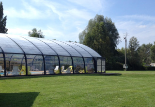 Überdachtes Schwimmbad mit Liegestühlen im Camping Seasonova Les Marguerites in Hauts-de-France, Frankreich.