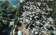 Luftfoto af Camping Seasonova Les Marguerites i Hauts-de-France, Frankrig, omgivet af træer og søer.