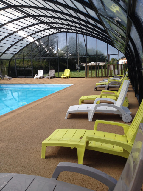 Piscina coperta con lettini gialli e bianchi al Camping Seasonova Les Marguerites, Hauts-de-France, Francia.