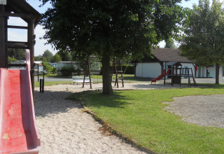 Parco giochi con scivoli, altalene e alberi presso il Camping Seasonova Les Marguerites, Hauts-de-France.