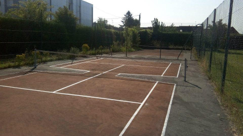 Cancha de tenis inusual con líneas superpuestas en Camping Seasonova Les Marguerites, Hauts-de-France, Francia.