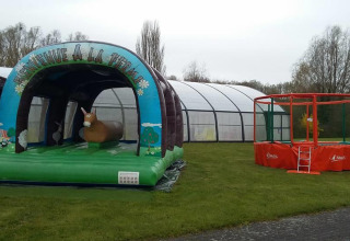 Giochi gonfiabili e trampolino sull'erba al Camping Seasonova Les Marguerites, Hauts-de-France, Francia.