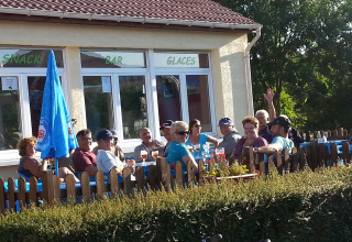 Gruppe campister nyder drikkevarer udendørs ved Camping Seasonova Les Marguerites i Hauts-de-France, Frankrig.