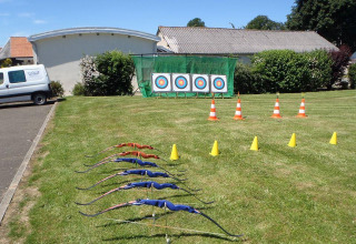 Bue og bueskydning mål sat op på græsplænen ved Camping Seasonova Les Marguerites i Hauts-de-France.