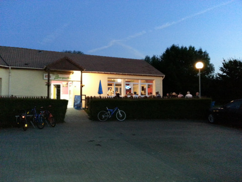 Foto serale di un edificio illuminato con ospiti al Camping Seasonova Les Marguerites in Hauts-de-France.