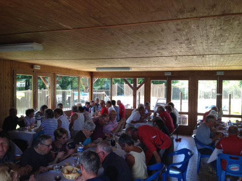 Personas compartiendo una comida en mesas largas en el Camping Seasonova Les Marguerites, Hauts-de-France, Francia.